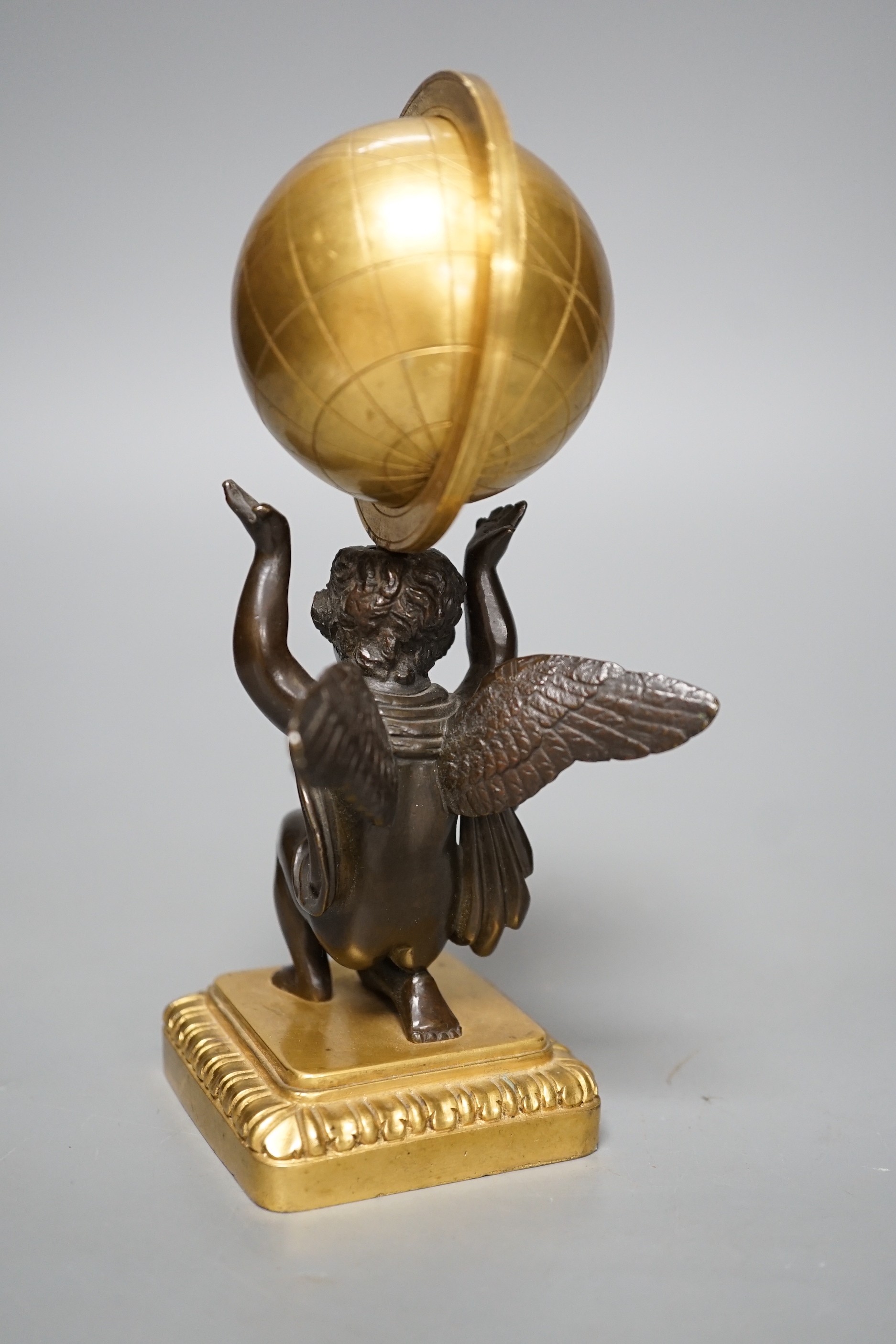 A late 19th century bronze and ormolu model of a cherub supporting a globe, 16cm